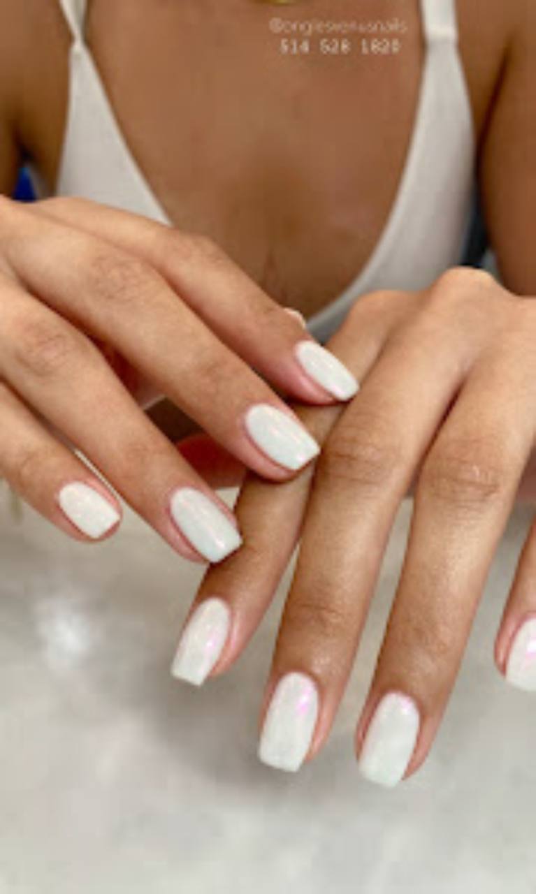 Neutral manicure displayed on a soft salon surface.